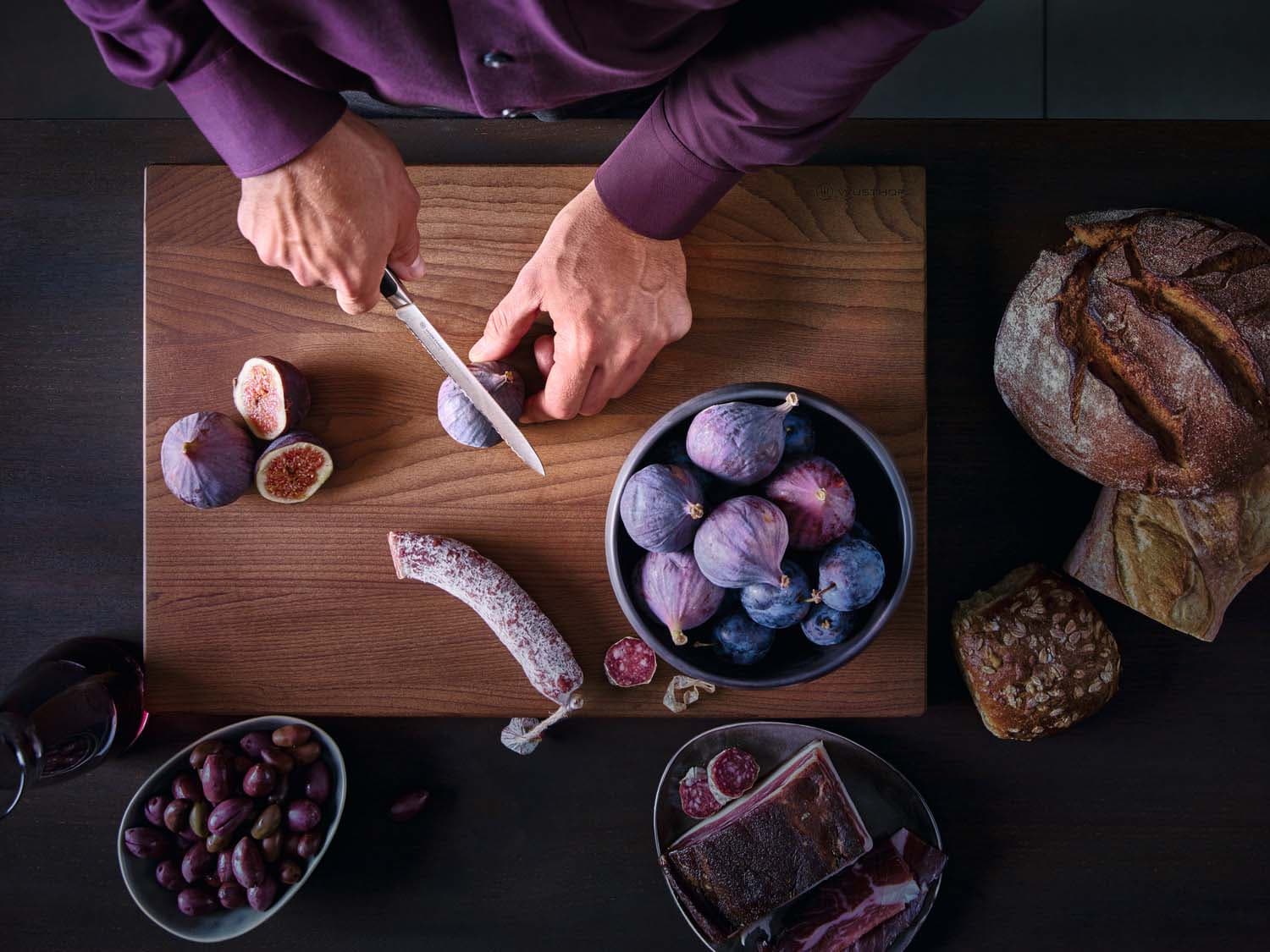 View from above: Chef in a kitchen slicing figs