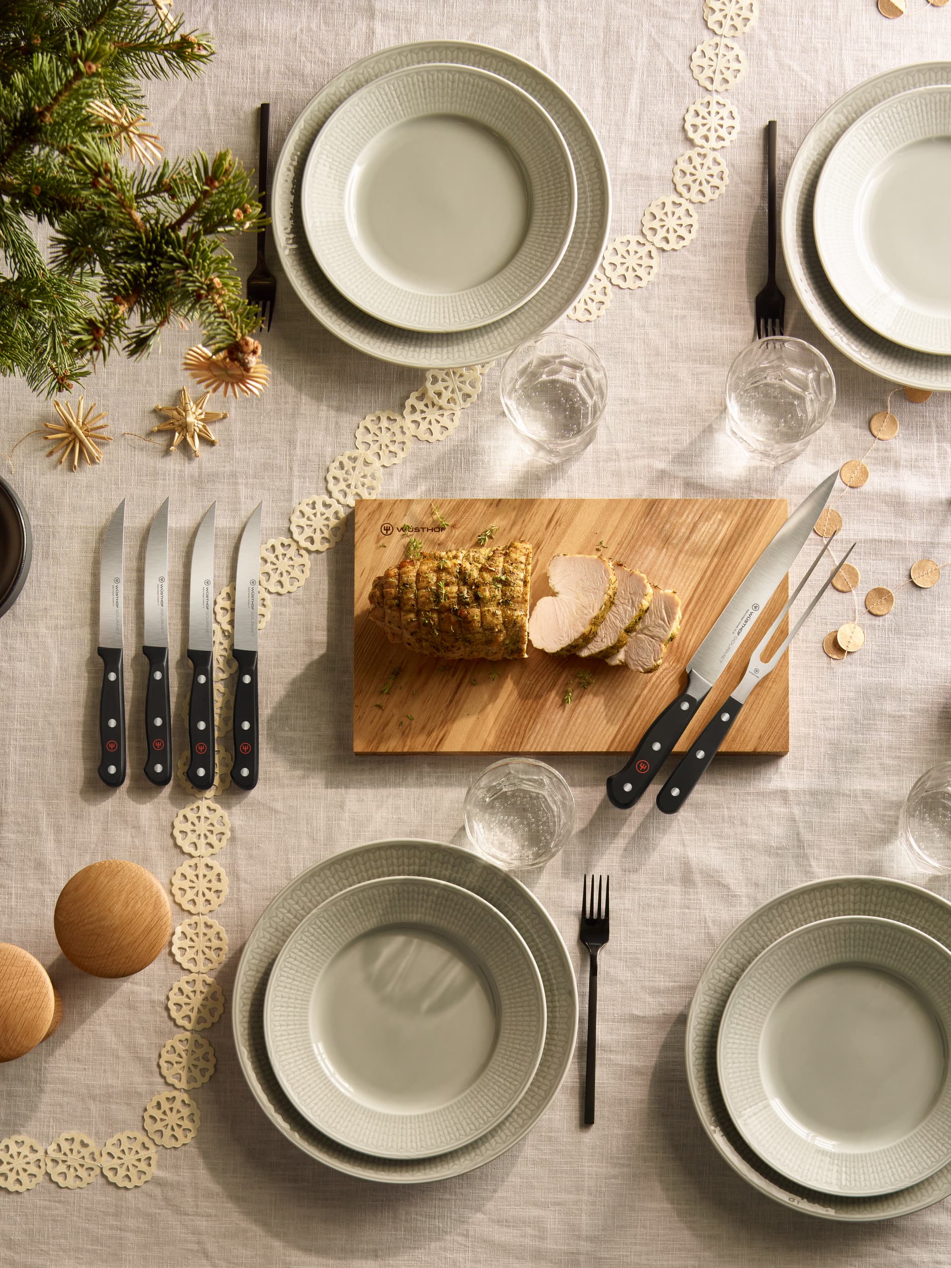 steak knife and carving knife set on holiday table next to place settings
