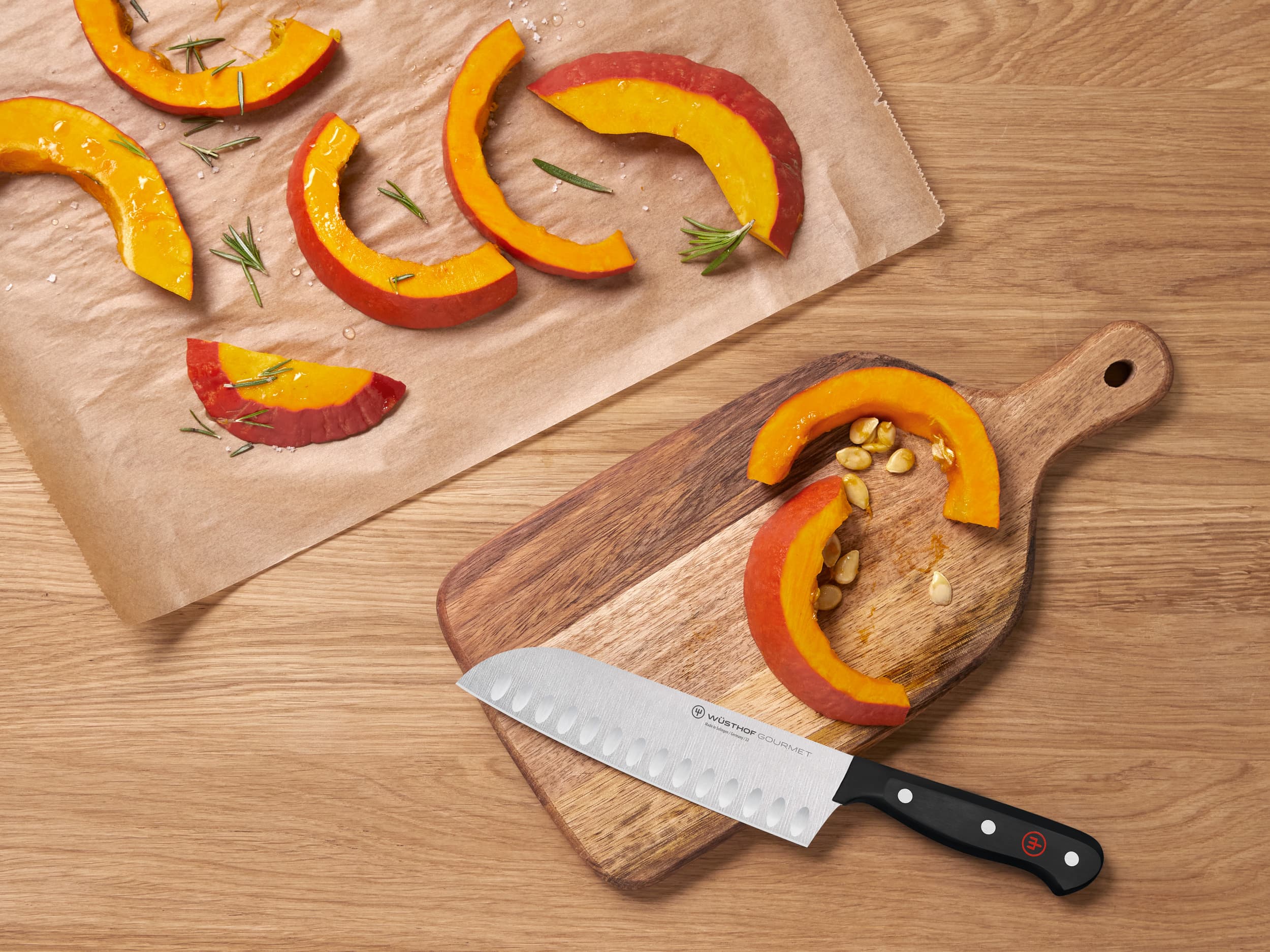 Gourmet black knife on cutting board near sliced fruit and nuts